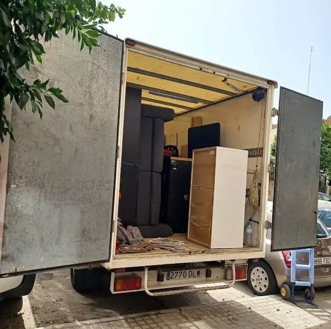 Camión con las puertas abiertas cargando muebles durante un vaciado de piso en Sevilla