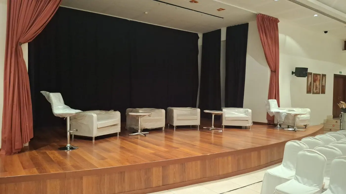 Mobiliario transportado y montado en el escenario de un auditorio para un evento de empresa
